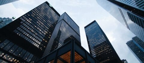 Bottom up view of financial buildings against a cloudy sky.
